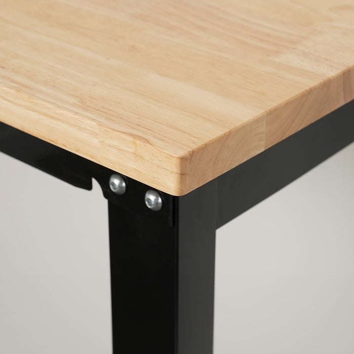 Corner detail of wooden workbench top with black metal legs.