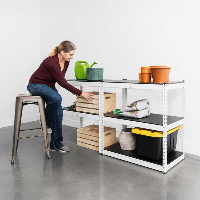 A woman reaches for a basket on a white shelving unit in a garage. The shelves are filled with pots, baskets, and other gardening supplies. The shelving is assembled in two columns, 72 inches wide total and 36 inches tall.