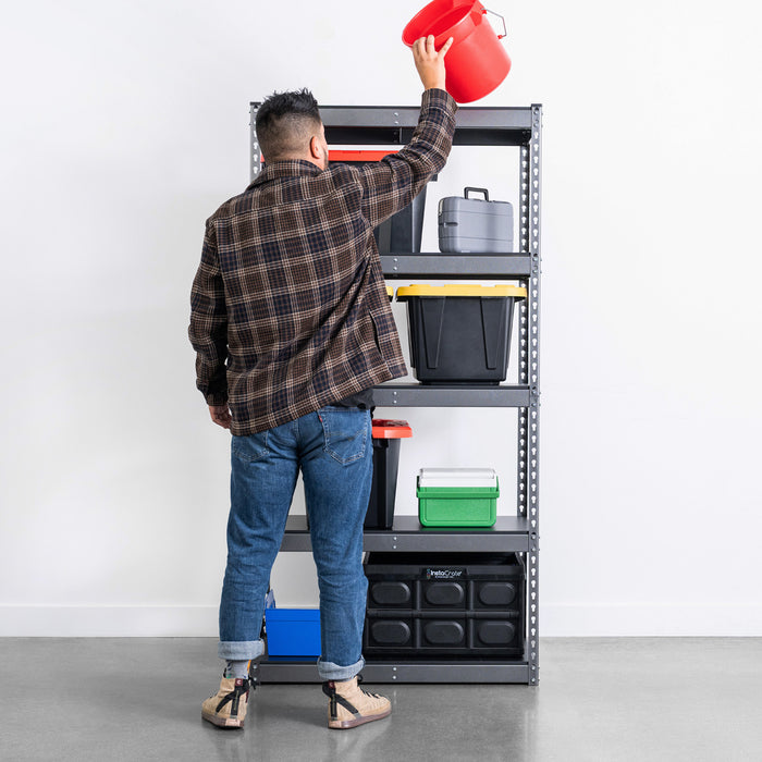 A man reaches for storage on a textured grey shelving unit in a garage. The shelves are filled with bins, boxes, and other garage gear. 36 inches wide and 72 inches tall.
